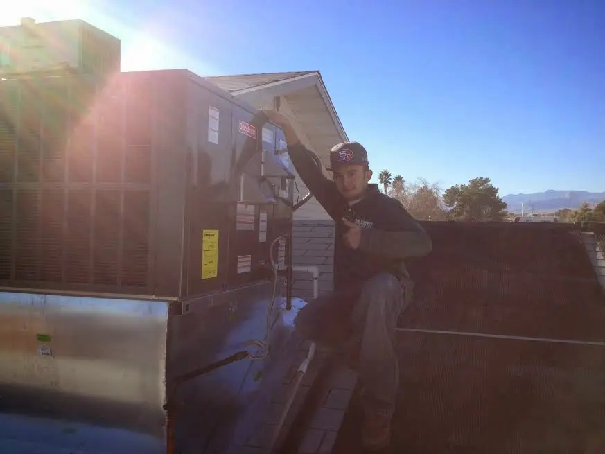HVAC technician performing AC Tune-Up on a rooftop unit in Isanti